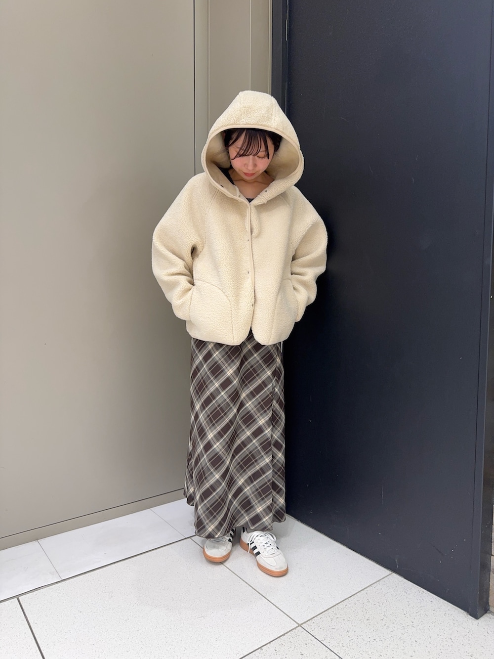 ホワイト系のムートンコート、ブラウン系のスカートを着用したレディースの冬コーディネートの3枚目の写真