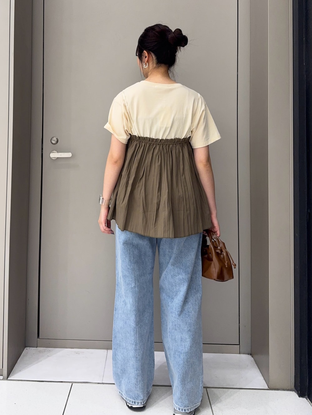 グリーン系のその他トップス、ブルー系のデニムパンツ、グレー系のスニーカーを着用したレディースの夏コーディネートの3枚目の写真