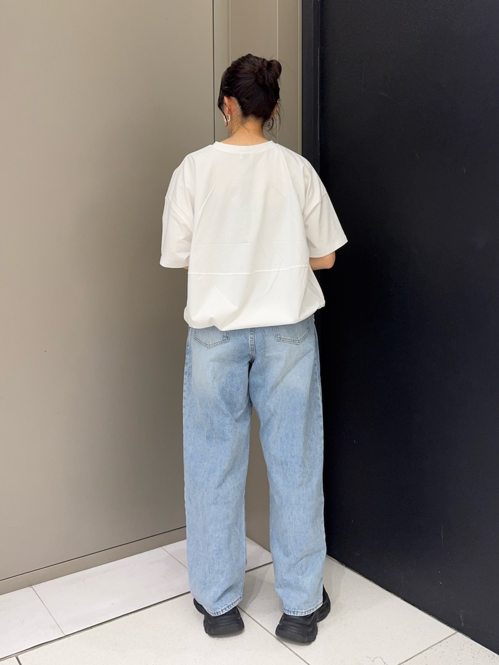 ホワイト系のTシャツ/カットソー、ブルー系のデニムパンツ、ブラック系のスニーカーを着用したレディースの春コーディネートの3枚目の写真