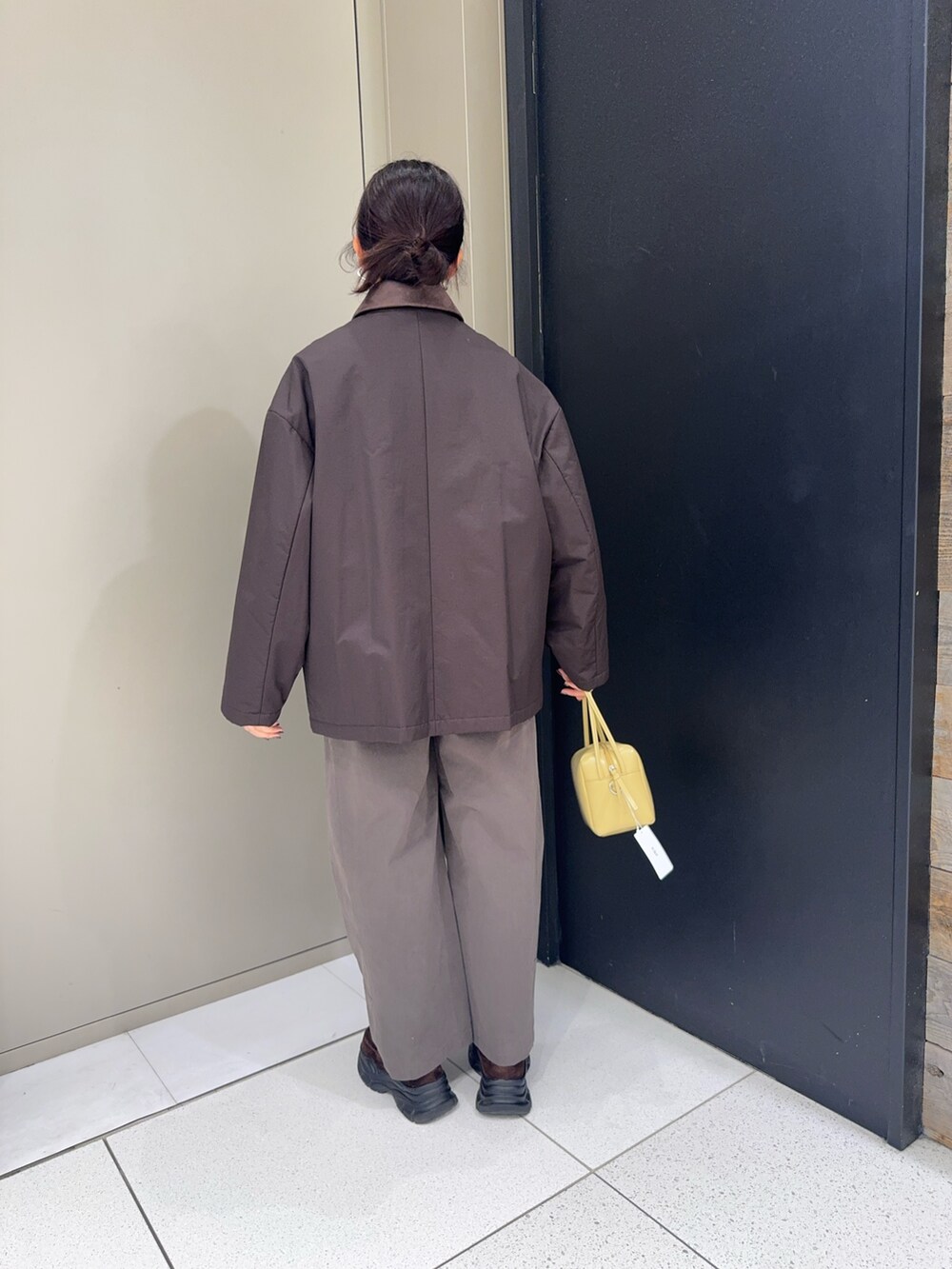 ブラウン系のダウンジャケット/コート、ベージュ系のショルダーバッグ、グレー系のその他パンツを着用したレディースの冬コーディネートの3枚目の写真