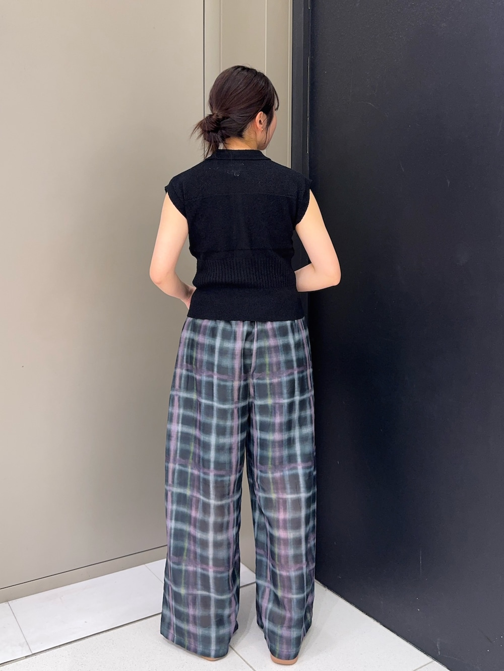 ブラック系のニット/セーター、グリーン系のその他パンツ、ホワイト系のスニーカーを着用したレディースの春コーディネートの2枚目の写真