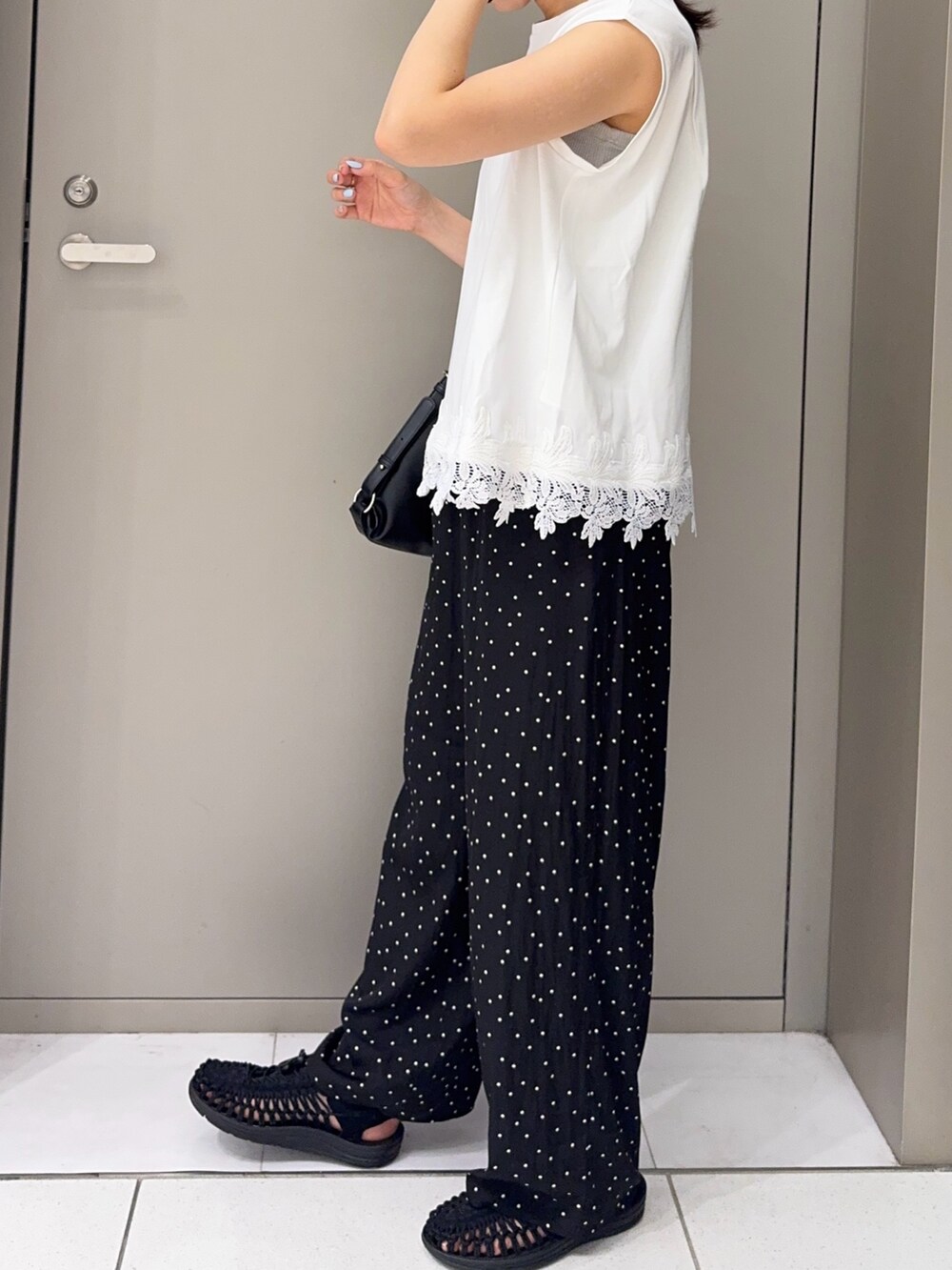 ブラック系のショルダーバッグ、ホワイト系のTシャツ/カットソー、ブラック系のその他パンツを着用したレディースの夏コーディネートの2枚目の写真