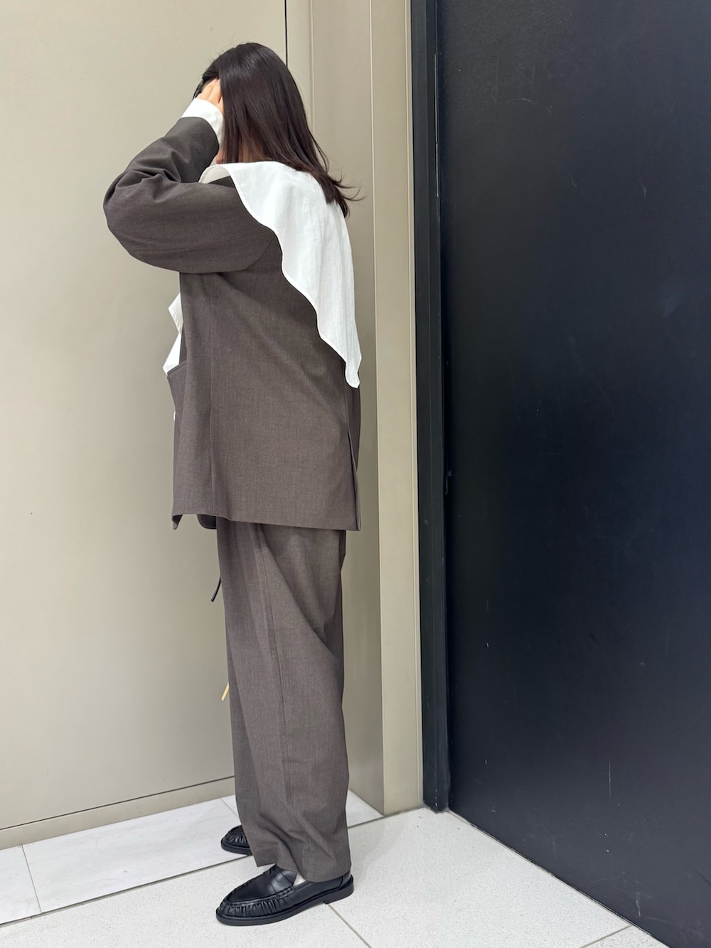 ブラウン系のノーカラージャケット、ブラウン系のその他パンツ、ベージュ系のショルダーバッグを着用したレディースの春コーディネートの2枚目の写真