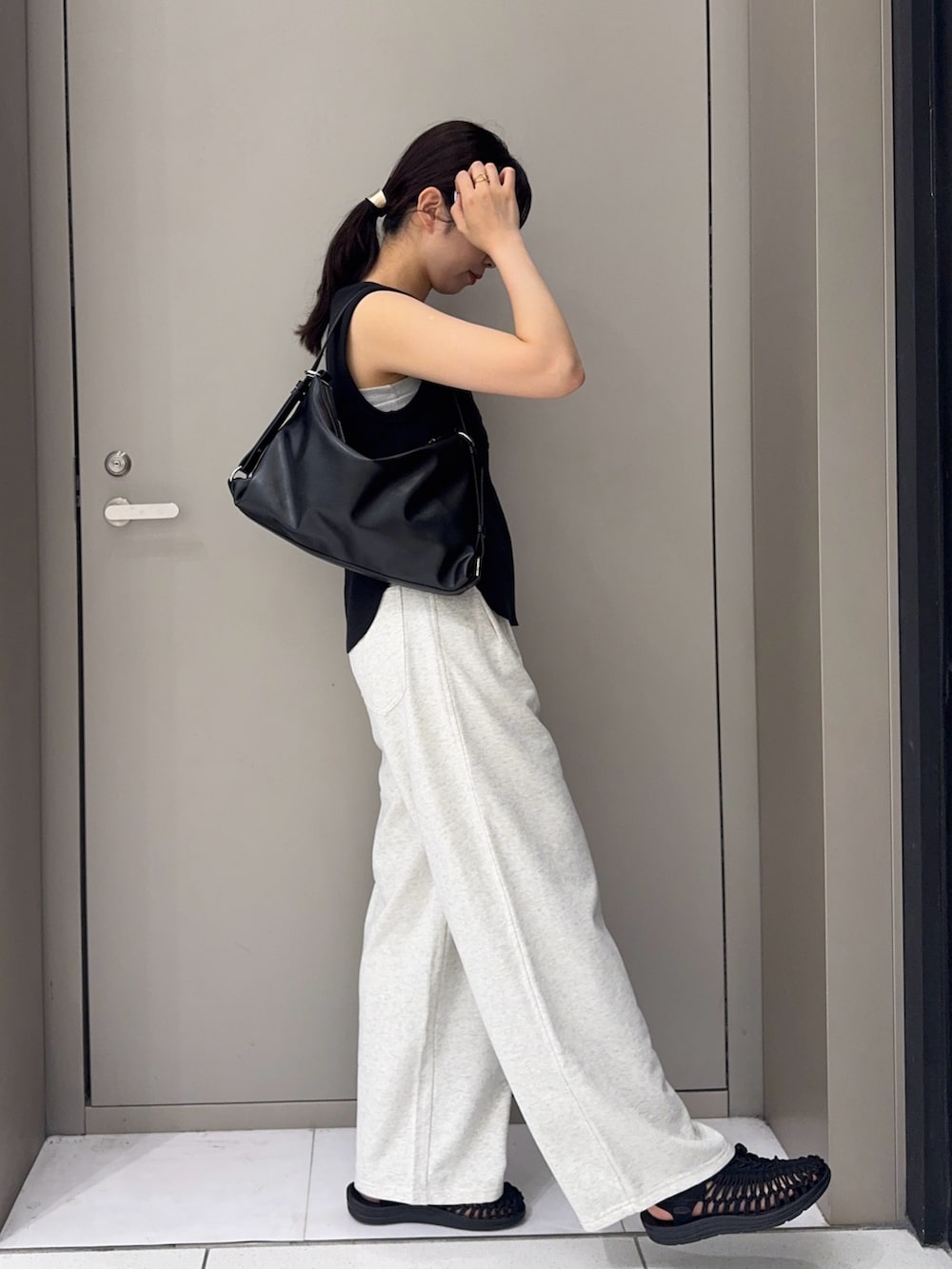 ホワイト系のその他パンツ、ブラック系のサンダル、ブラック系のショルダーバッグを着用したレディースの夏コーディネートの2枚目の写真