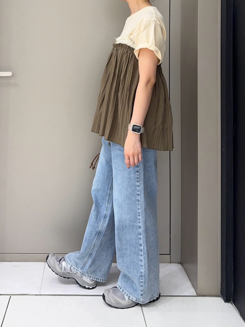 グリーン系のその他トップス、ブルー系のデニムパンツ、グレー系のスニーカーを着用したレディースの夏コーディネートの2枚目の写真