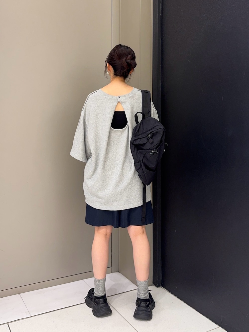 グレー系のスウェット、ブラック系のスニーカー、ブラック系のバックパック/リュックを着用したレディースの夏コーディネートの3枚目の写真