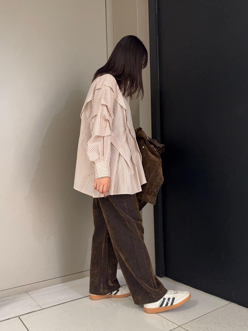 ブラウン系のブルゾン、ピンク系のシャツ/ブラウス、ブラウン系のデニムパンツを着用したレディースの冬コーディネートの3枚目の写真