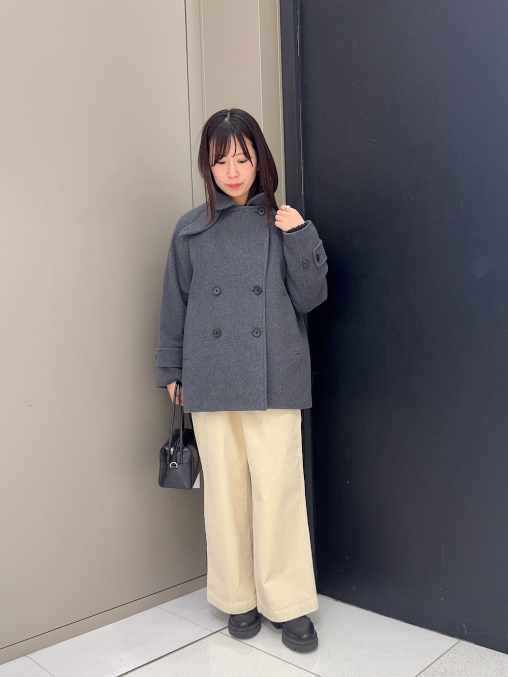 グレー系のピーコートを着用したレディースの冬コーディネートの2枚目の写真