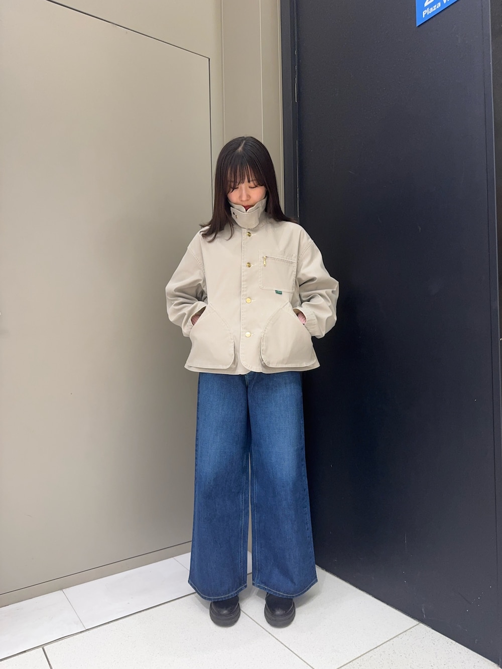 ベージュ系のテーラードジャケット、ブルー系のデニムパンツを着用したレディースの冬コーディネートの4枚目の写真