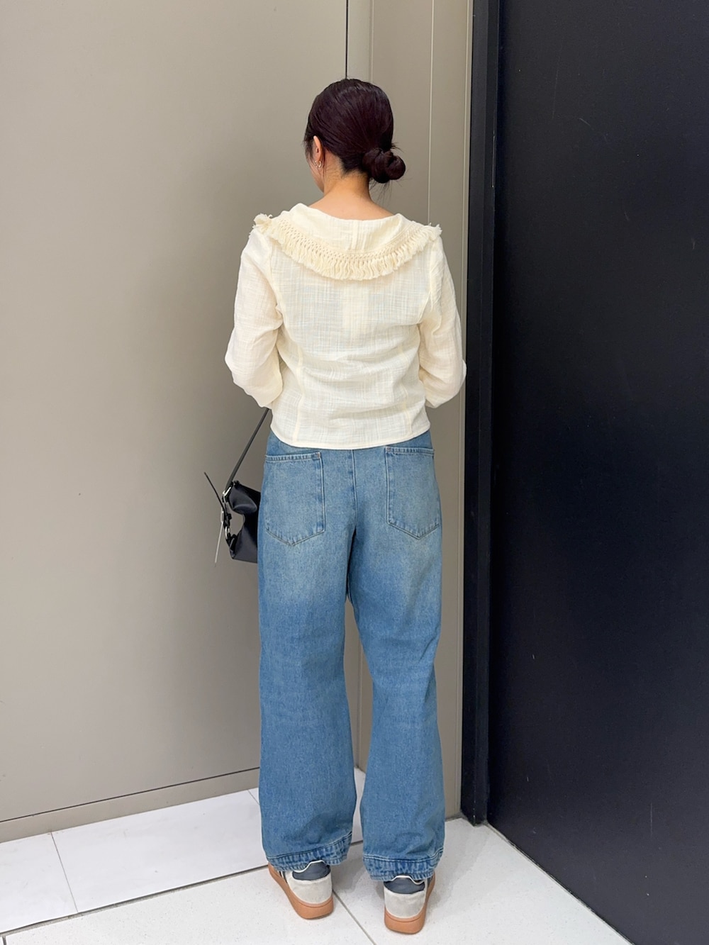 ホワイト系のシャツ/ブラウス、ブルー系のデニムパンツ、ホワイト系のスニーカーを着用したレディースの秋コーディネートの3枚目の写真