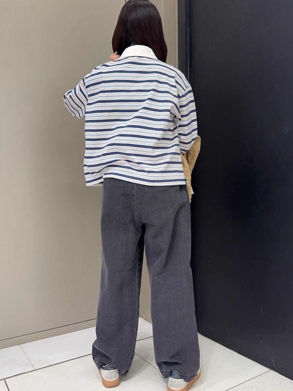 ブルー系のTシャツ/カットソー、ブラック系のデニムパンツ、ホワイト系のスニーカーを着用したレディースの春コーディネートの2枚目の写真