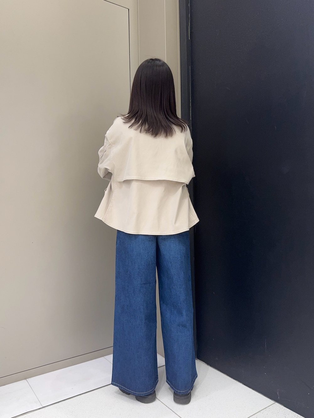 ベージュ系のテーラードジャケット、ブルー系のデニムパンツを着用したレディースの冬コーディネートの2枚目の写真