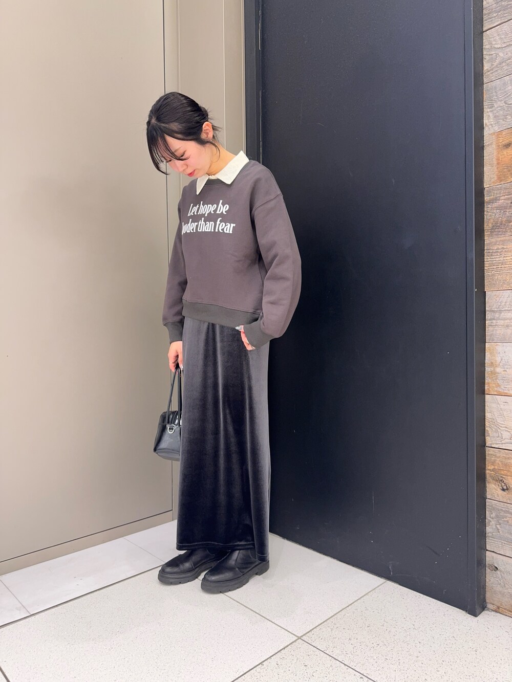 グレー系のスウェット、ホワイト系のシャツ/ブラウス、ブラック系のショルダーバッグを着用したレディースの冬コーディネートの2枚目の写真