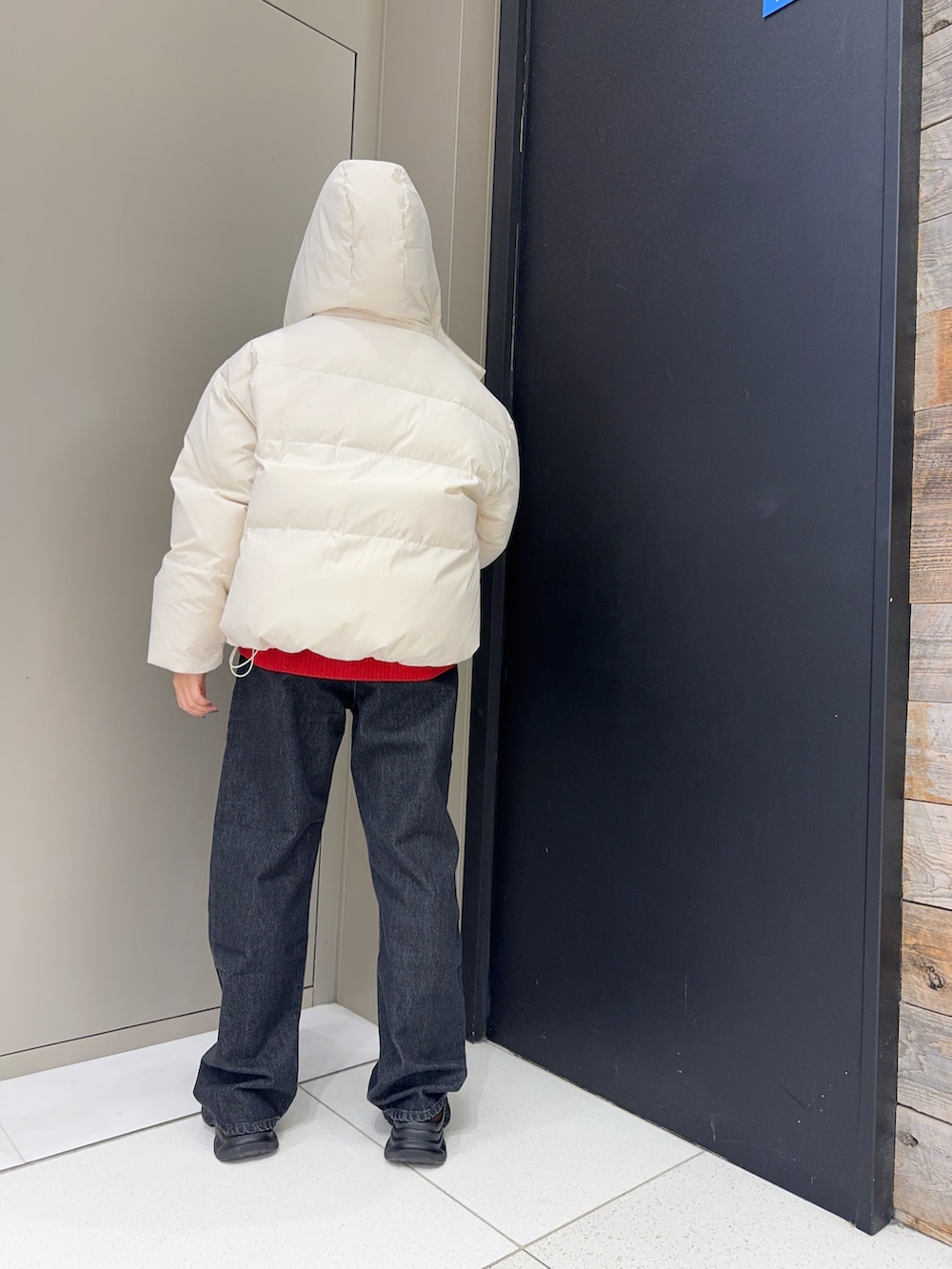 ホワイト系のダウンジャケット/コート、ブラック系のデニムパンツ、ブラウン系のローファーを着用したレディースの冬コーディネートの4枚目の写真