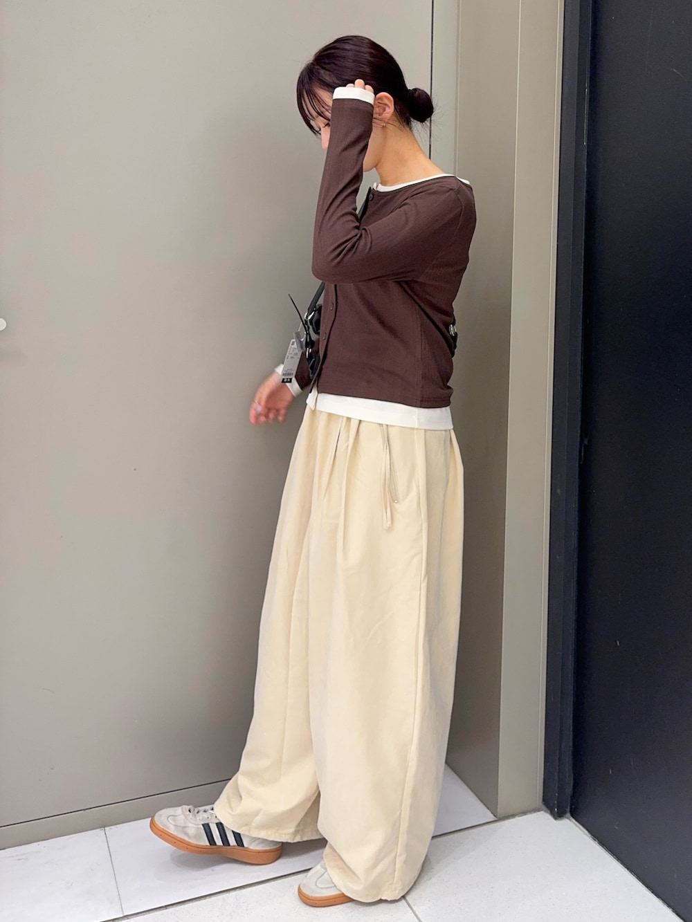 ベージュ系のその他パンツ、ホワイト系のスニーカー、ブラック系のショルダーバッグを着用したレディースの秋コーディネートの3枚目の写真