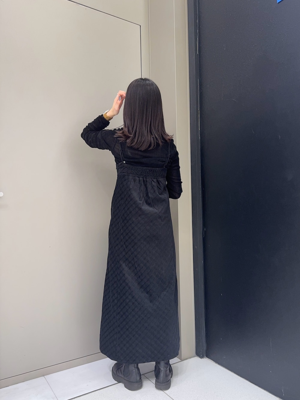 ブラック系のTシャツ/カットソー、ブラック系のワンピース、ホワイト系のハンドバッグを着用したレディースの冬コーディネートの2枚目の写真