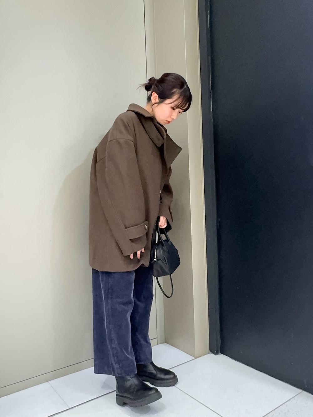 ブラウン系のその他アウター、ブラック系のハンドバッグ、ブルー系のその他パンツを着用したレディースの冬コーディネートの2枚目の写真