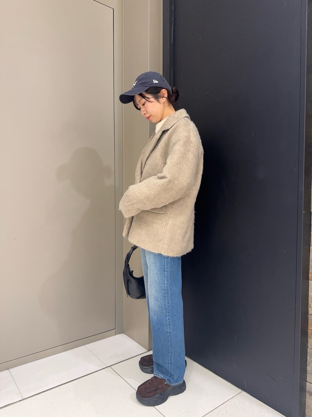 ブラウン系のその他アウター、ブルー系のデニムパンツ、ブラウン系のローファーを着用したレディースの冬コーディネートの2枚目の写真