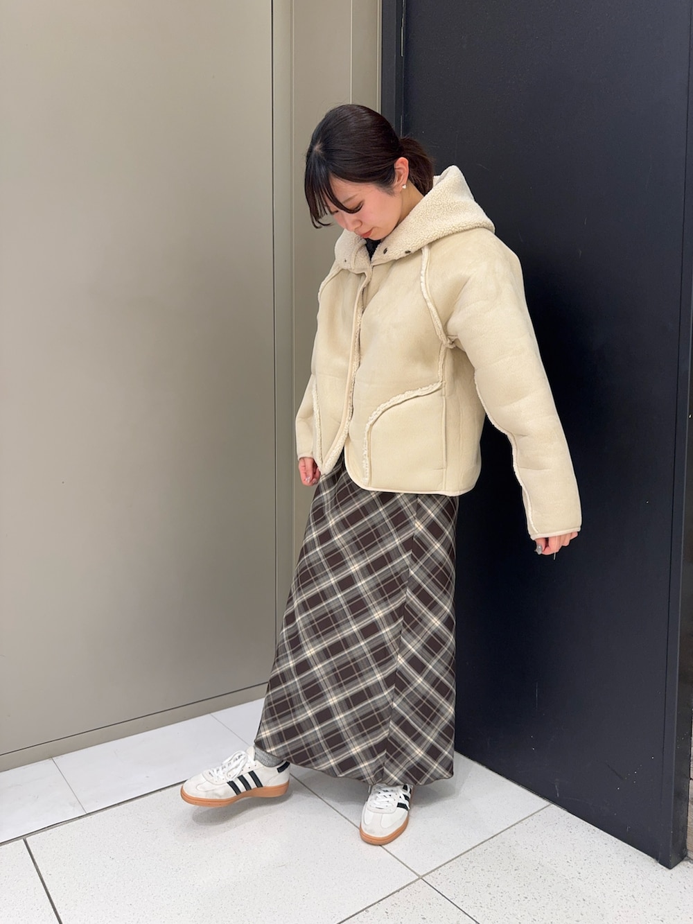 ホワイト系のムートンコート、ブラウン系のスカートを着用したレディースの冬コーディネートの4枚目の写真