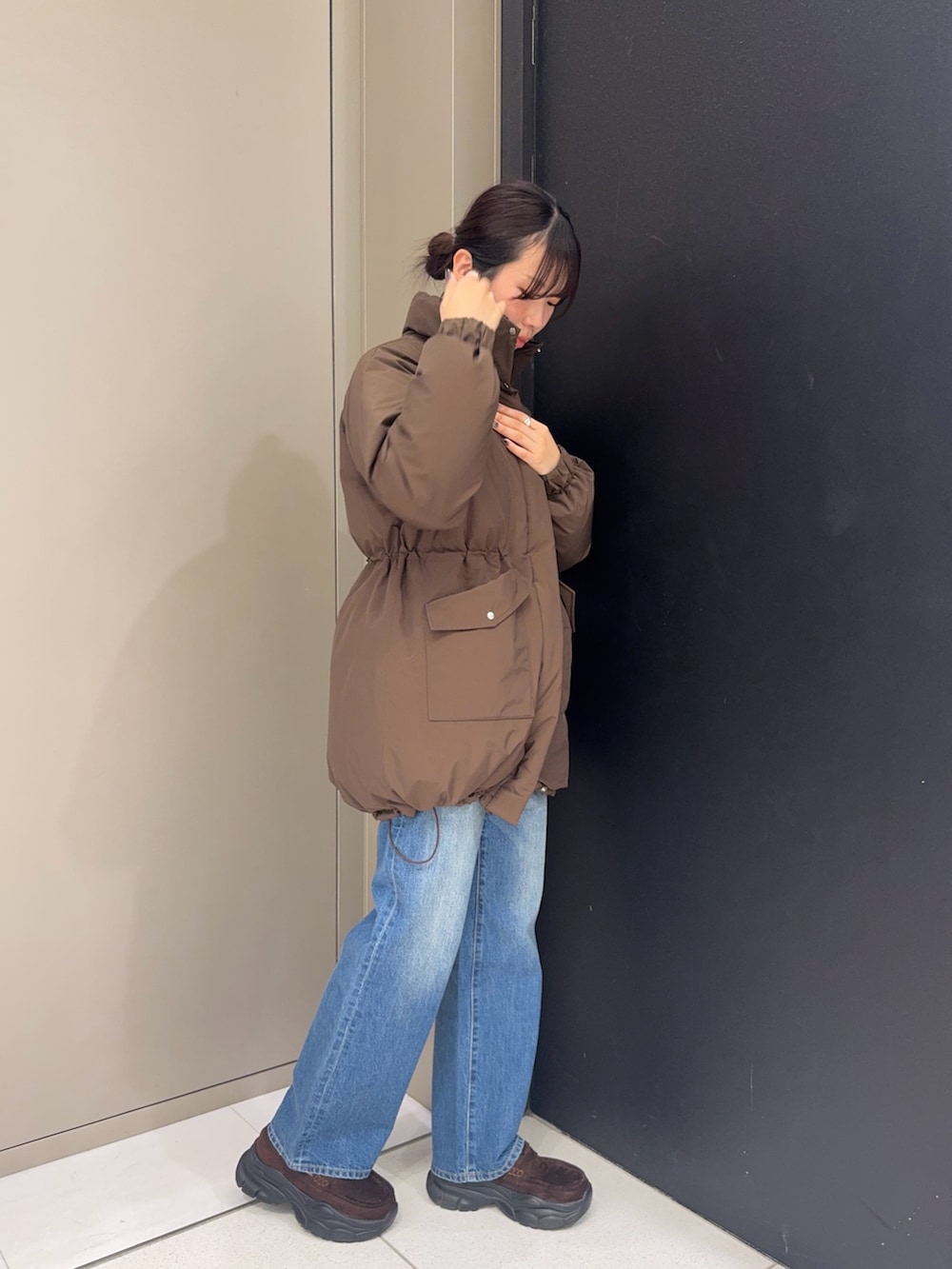 ブラウン系のダウンジャケット/コート、ブルー系のデニムパンツ、ブラウン系のローファーを着用したレディースの冬コーディネートの2枚目の写真