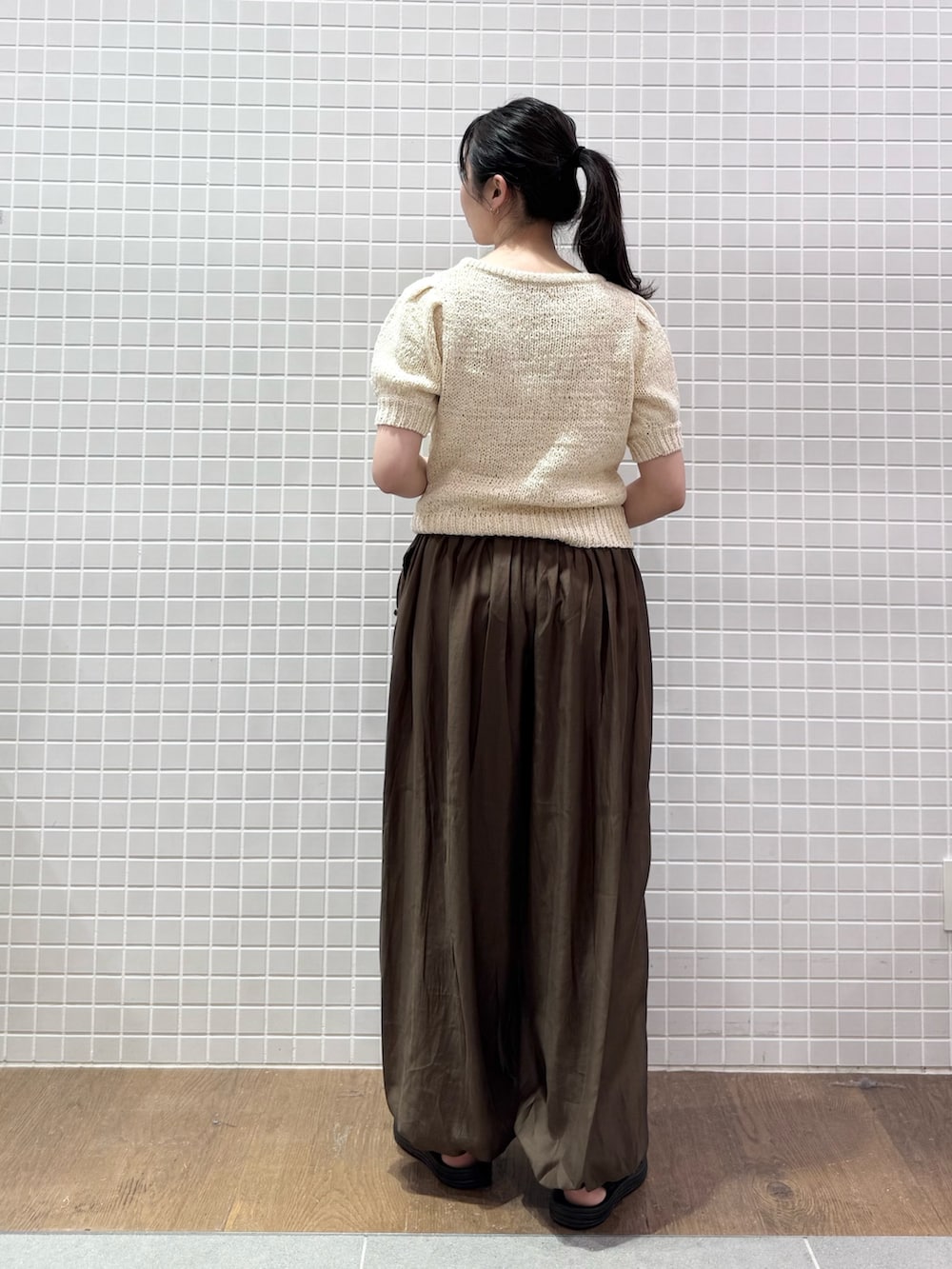 ホワイト系のニット/セーター、ブラウン系のハンドバッグ、ブラウン系のその他パンツを着用したレディースの夏コーディネートの2枚目の写真