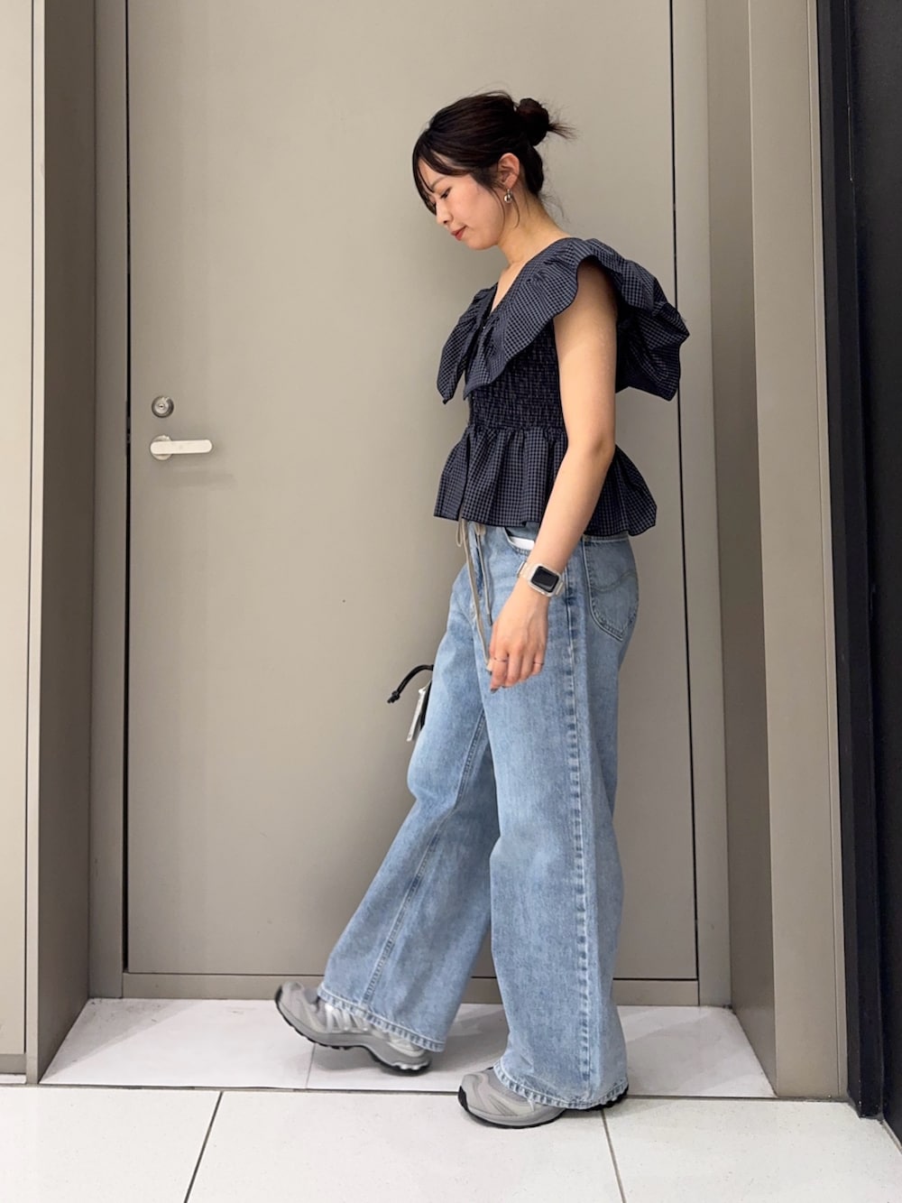 ブルー系のシャツ/ブラウス、ブラック系のハンドバッグ、ブルー系のデニムパンツを着用したレディースの夏コーディネートの3枚目の写真
