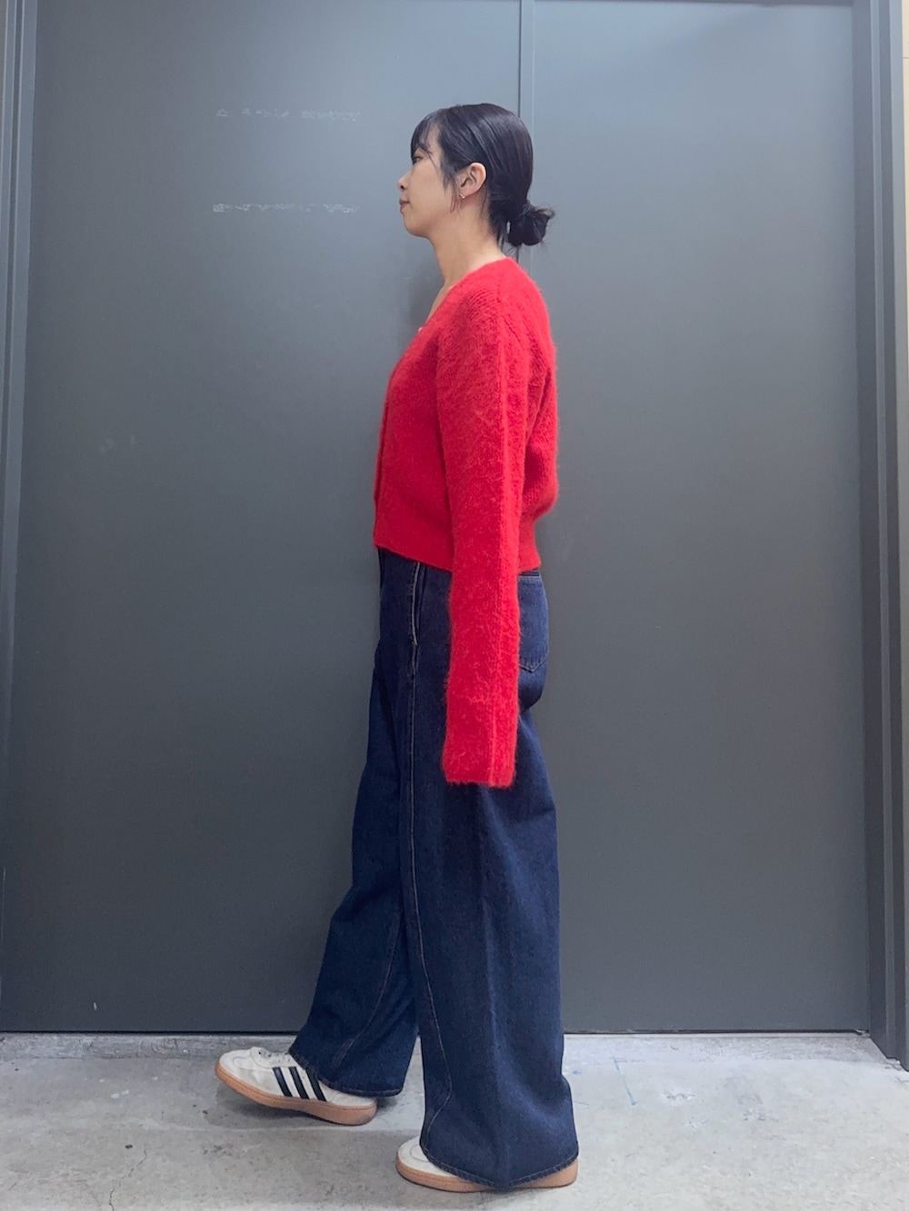 レッド系のカーディガン/ボレロ、ホワイト系のタンクトップ、ブルー系のデニムパンツを着用したレディースの秋コーディネートの3枚目の写真