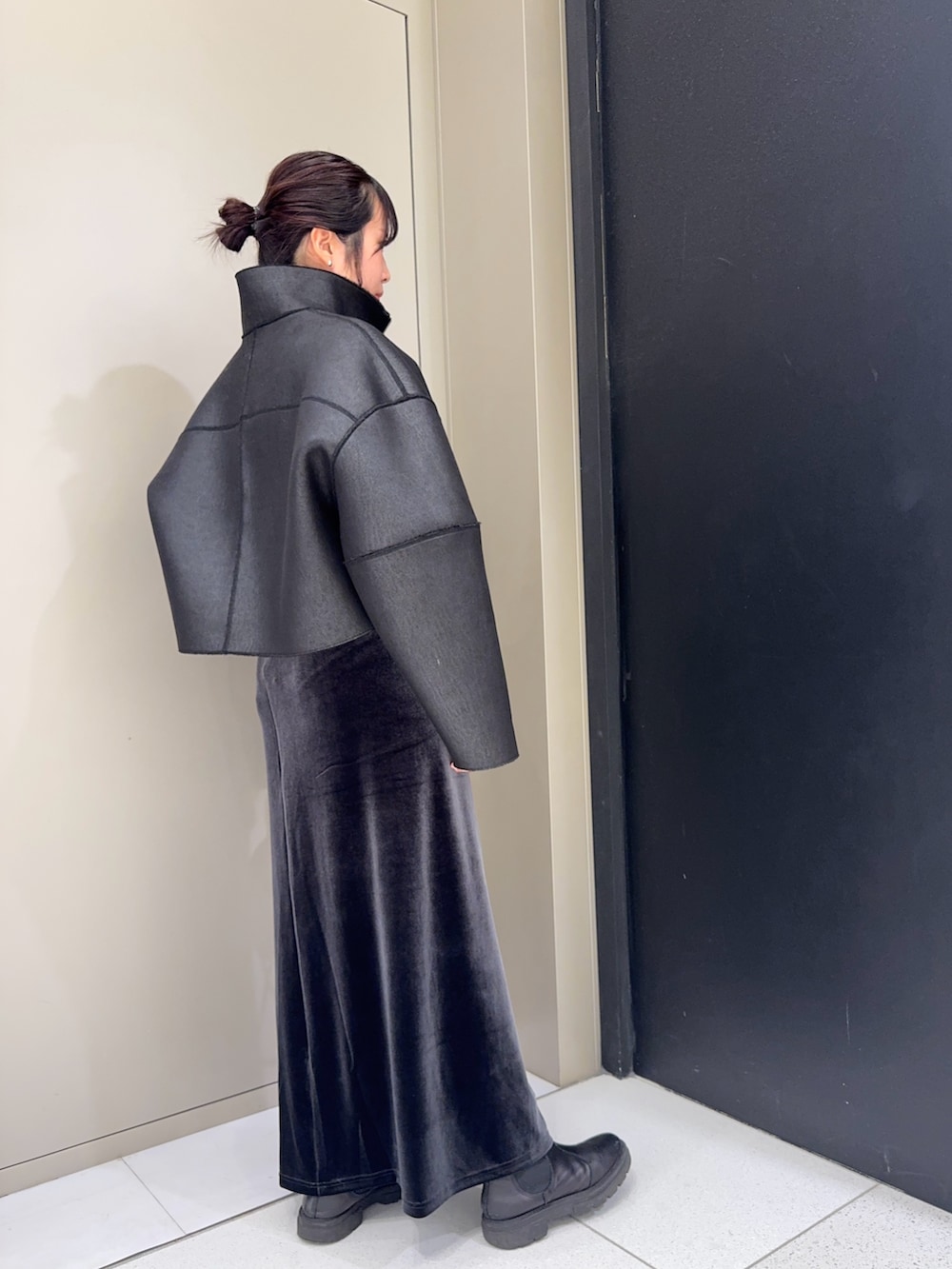 ブラック系のその他アウター、ブラック系のハンドバッグ、グレー系のスカートを着用したレディースの冬コーディネートの3枚目の写真