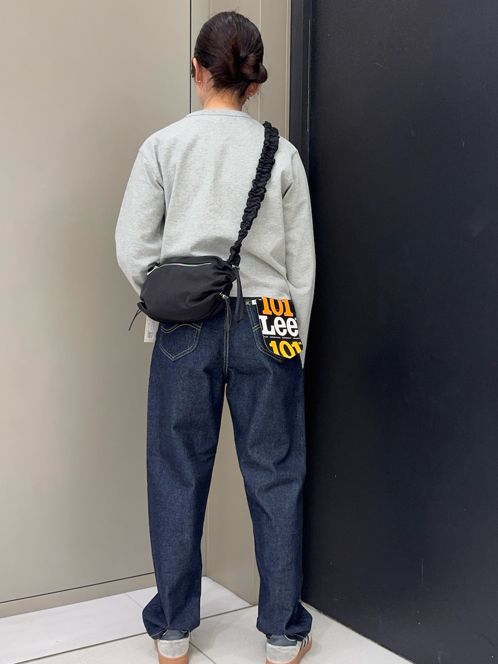 グレー系のカーディガン/ボレロ、ブルー系のデニムパンツ、ホワイト系のスニーカーを着用したレディースの春コーディネートの3枚目の写真