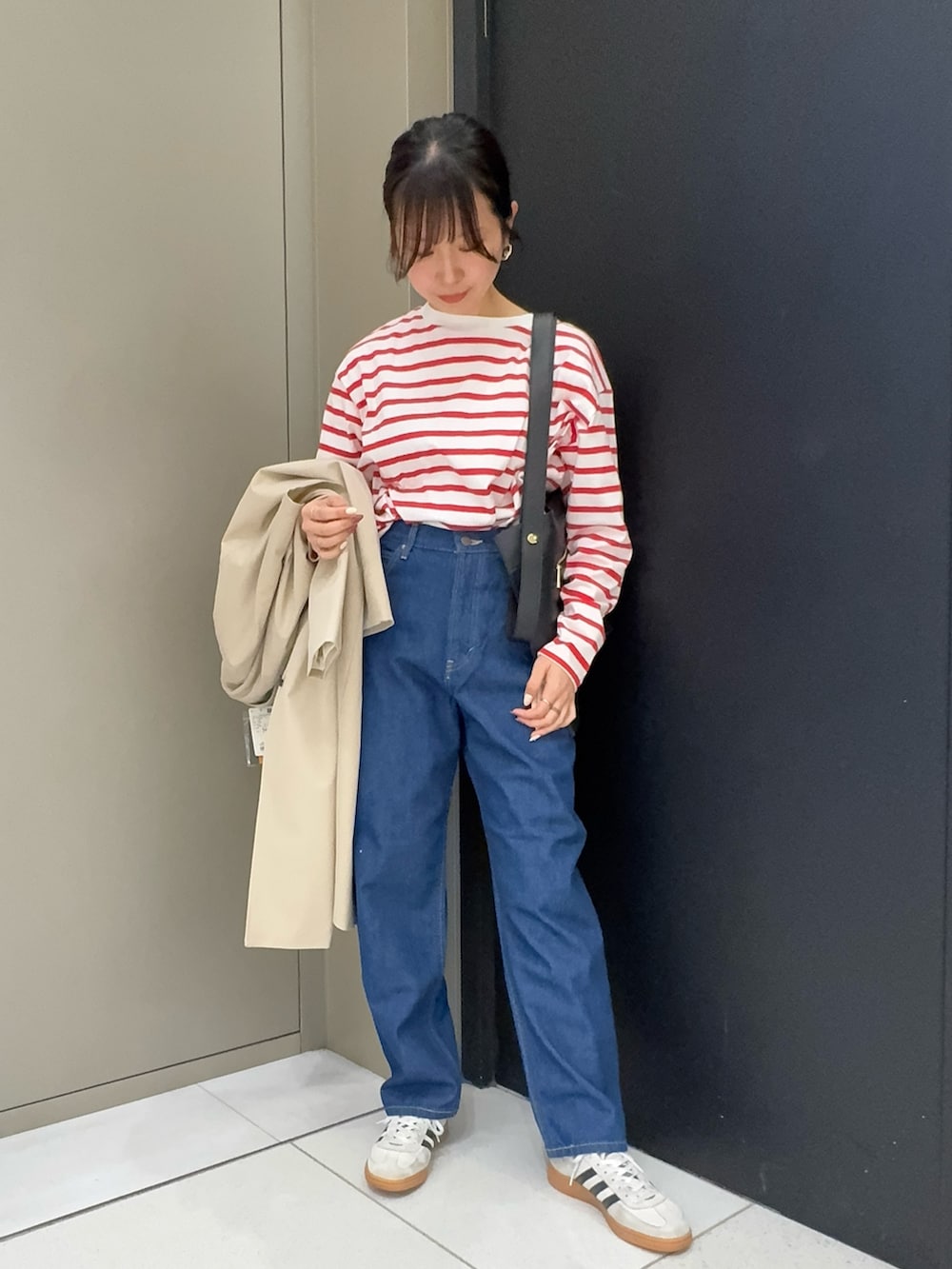 ベージュ系のその他アウター、レッド系のTシャツ/カットソー、ブルー系のデニムパンツを着用したレディースの春コーディネートの3枚目の写真