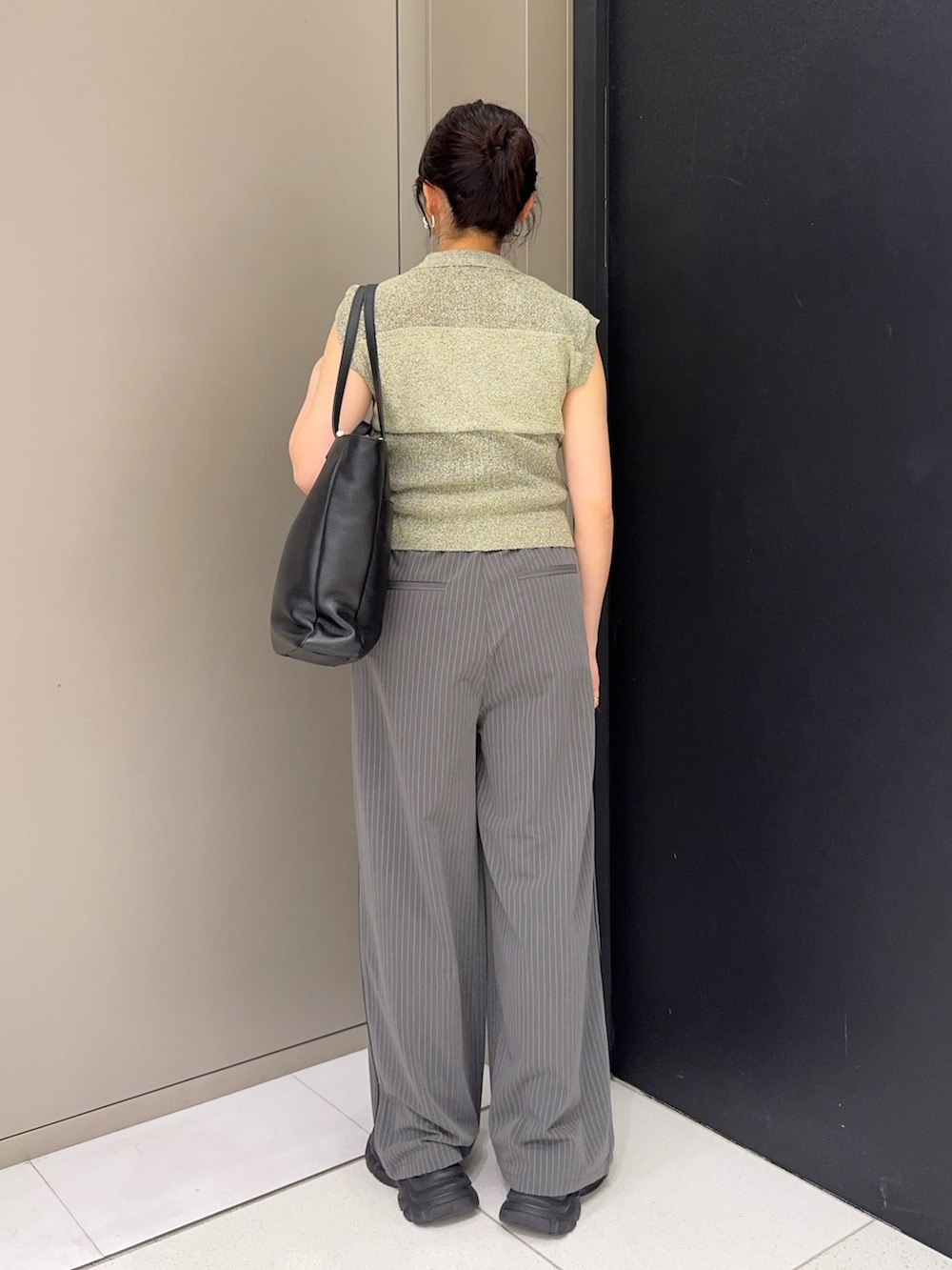 ブラック系のトートバッグ、グレー系のその他パンツ、ベージュ系のニット/セーターを着用したレディースの春コーディネートの3枚目の写真