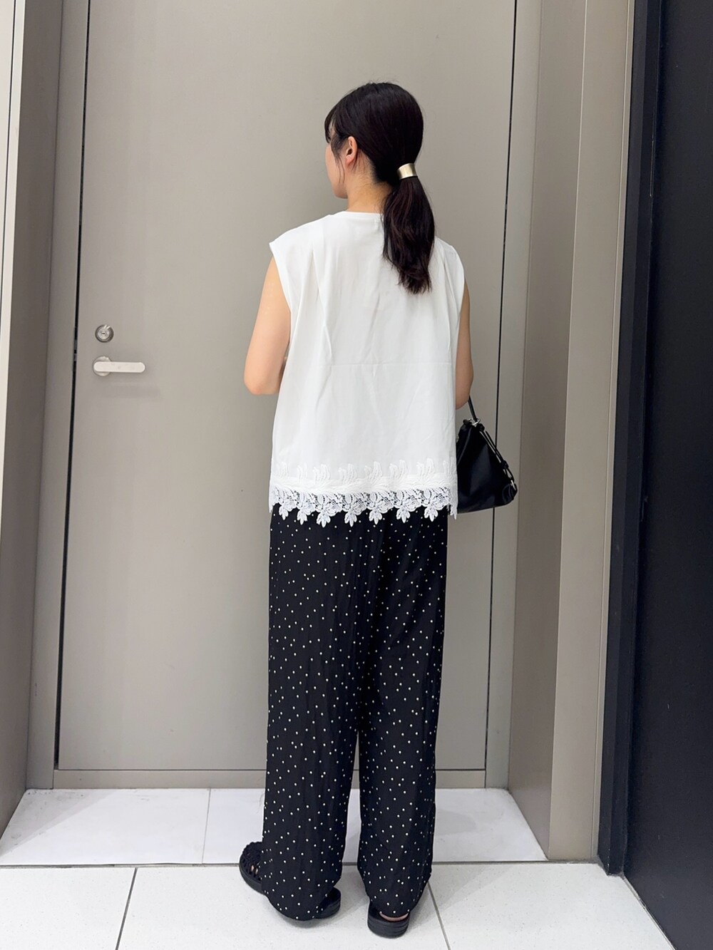 ブラック系のショルダーバッグ、ホワイト系のTシャツ/カットソー、ブラック系のその他パンツを着用したレディースの夏コーディネートの3枚目の写真
