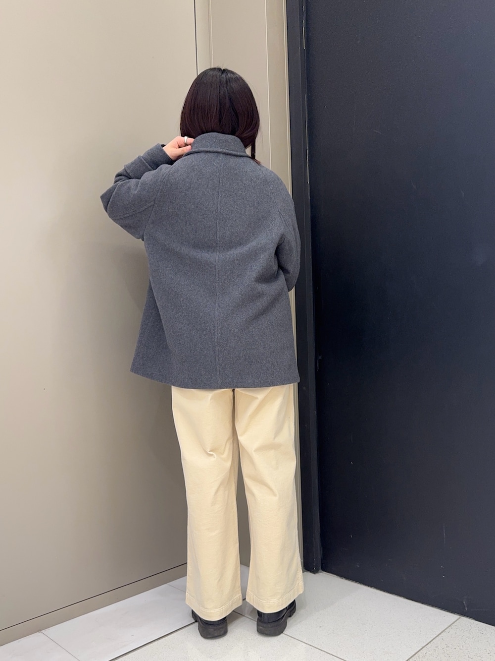 グレー系のピーコートを着用したレディースの冬コーディネートの4枚目の写真