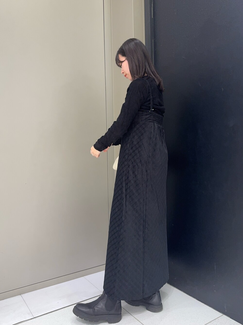 ブラック系のTシャツ/カットソー、ブラック系のワンピース、ホワイト系のハンドバッグを着用したレディースの冬コーディネートの3枚目の写真