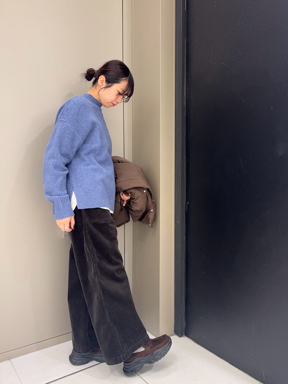 ブルー系のニット/セーター、グレー系のその他パンツ、ブラウン系のローファーを着用したレディースの冬コーディネートの2枚目の写真