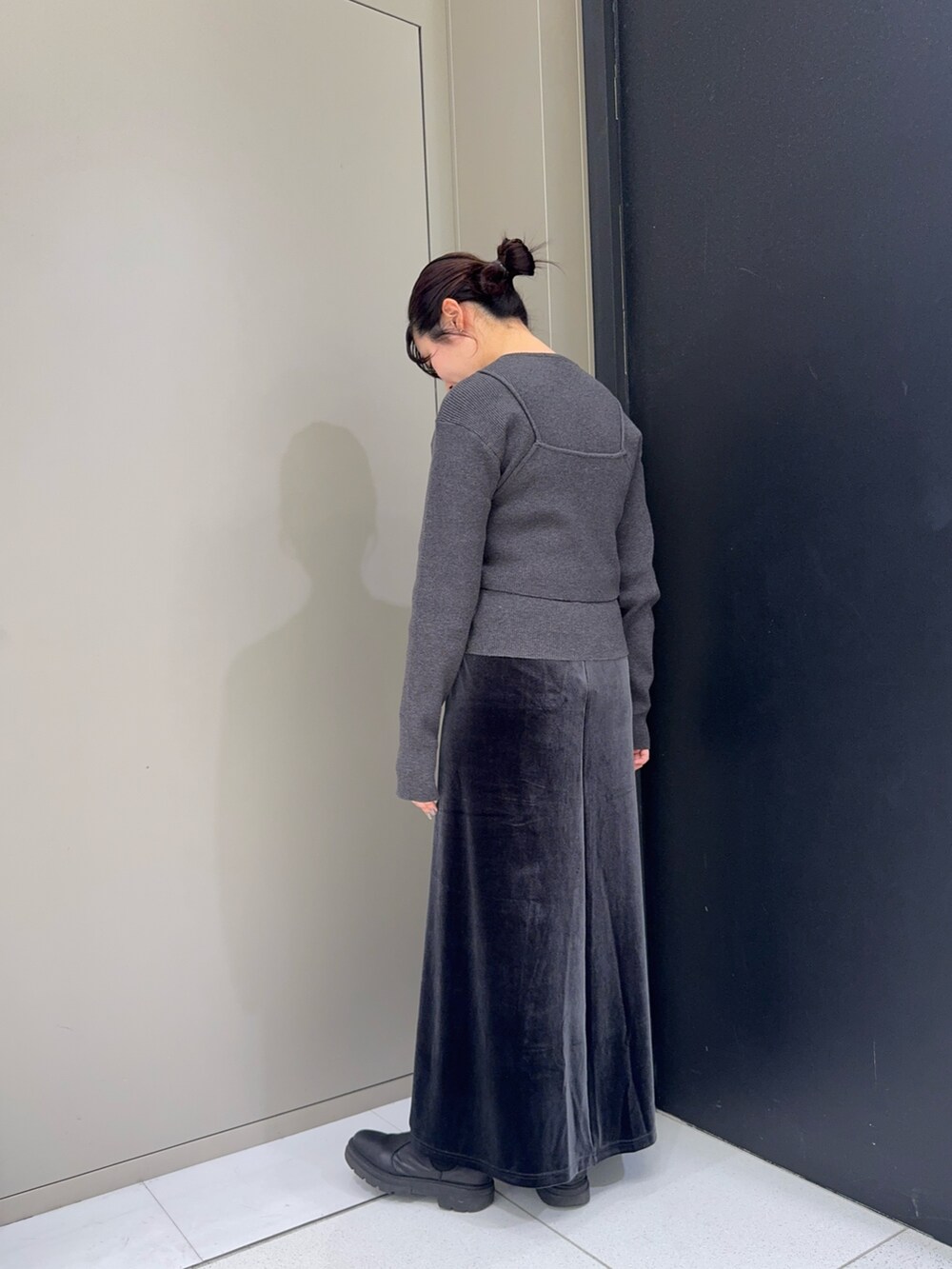 グレー系のニット/セーター、ブラック系のハンドバッグ、グレー系のスカートを着用したレディースの秋コーディネートの3枚目の写真