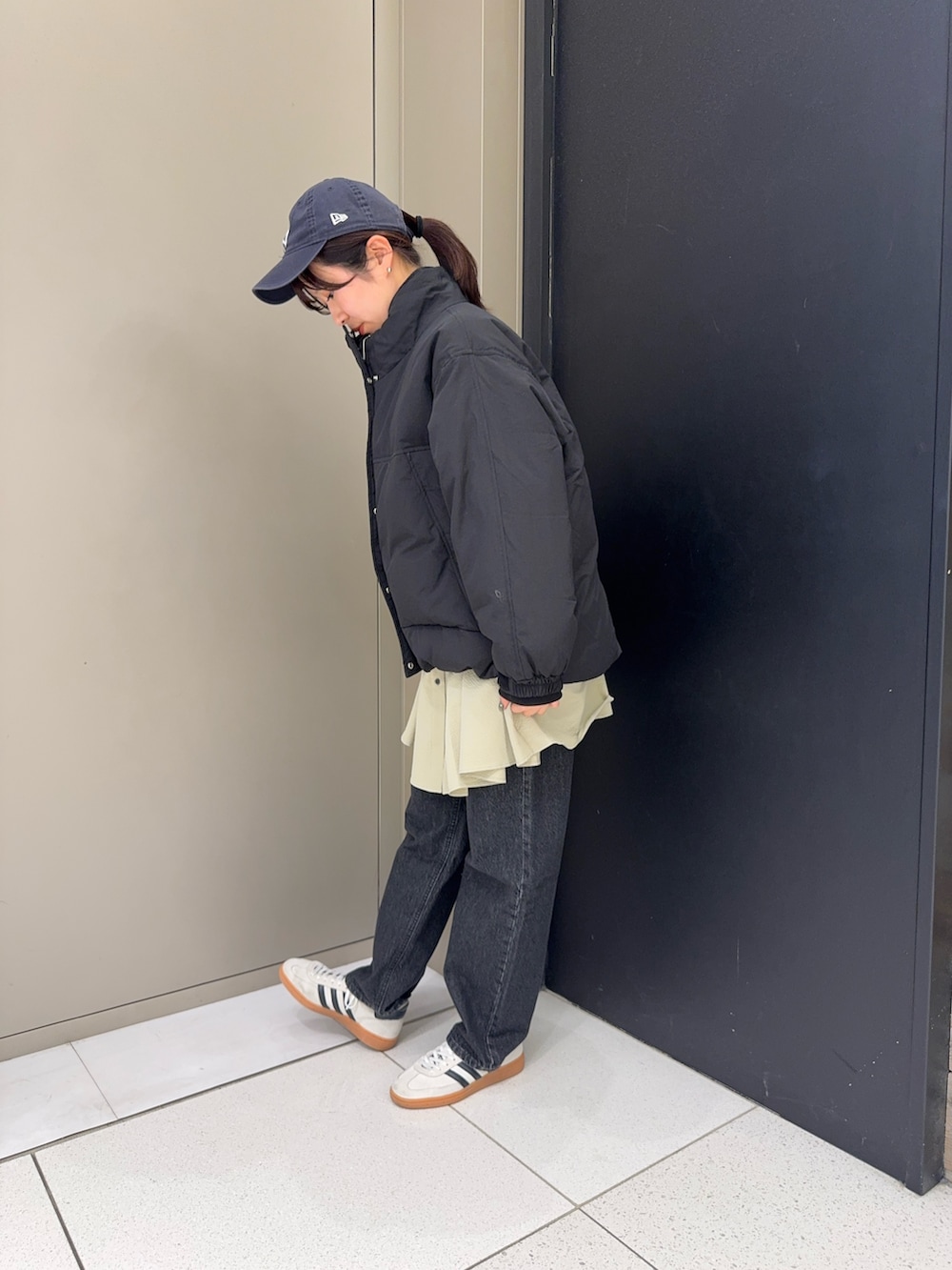 ブラック系のダウンジャケット/コート、グリーン系のシャツ/ブラウス、ブラック系のデニムパンツを着用したレディースの冬コーディネートの3枚目の写真