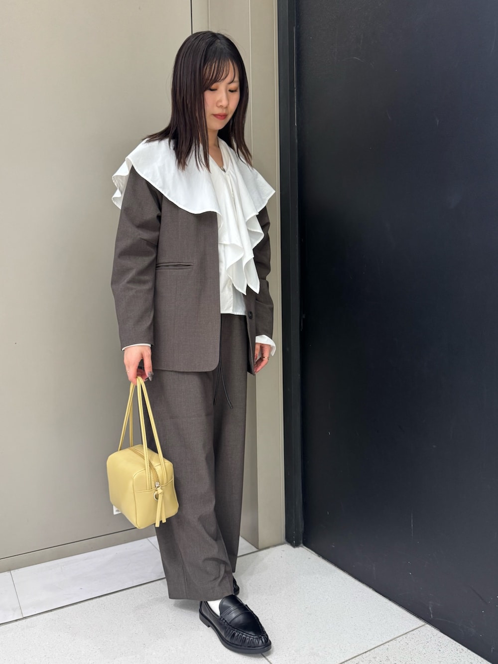 ブラウン系のノーカラージャケット、ブラウン系のその他パンツ、ベージュ系のショルダーバッグを着用したレディースの春コーディネートの3枚目の写真