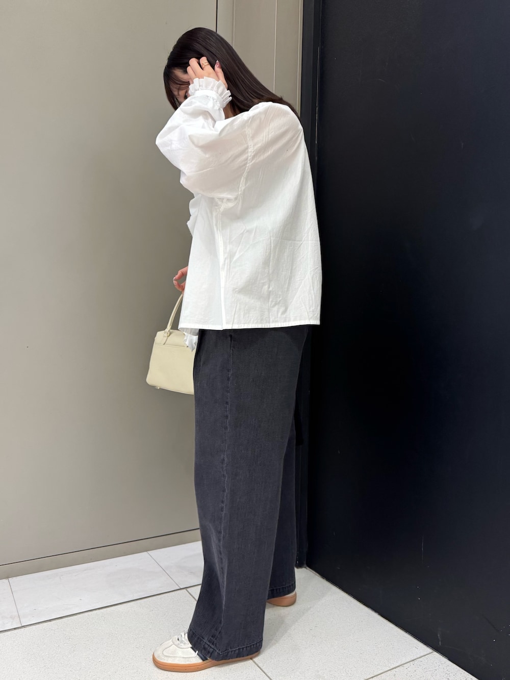 ホワイト系のシャツ/ブラウス、ブラック系のデニムパンツ、ホワイト系のスニーカーを着用したレディースの春コーディネートの2枚目の写真