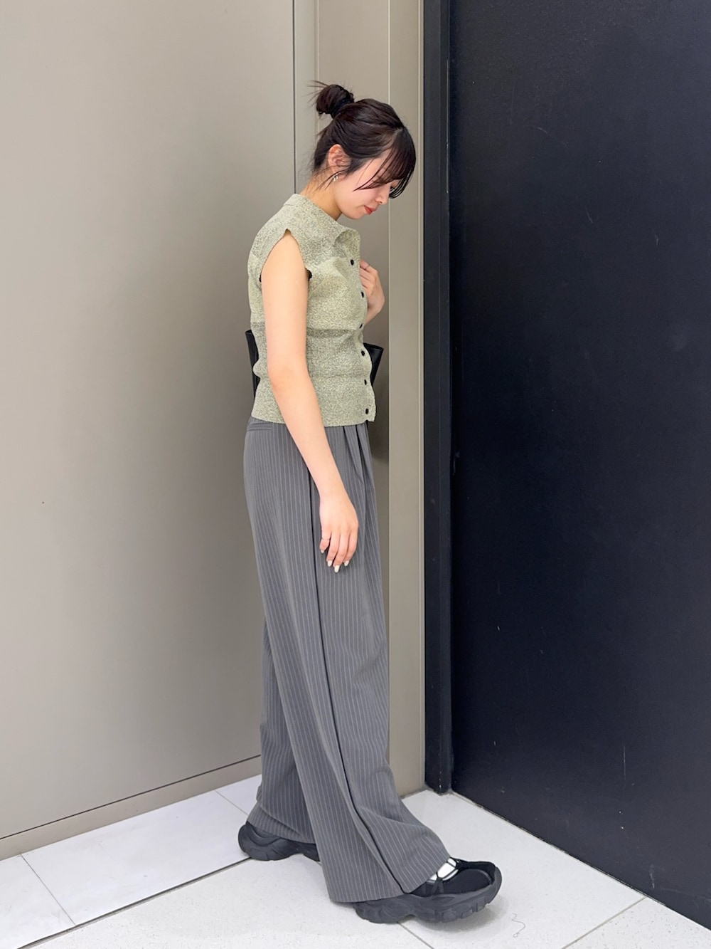 ブラック系のトートバッグ、グレー系のその他パンツ、ベージュ系のニット/セーターを着用したレディースの春コーディネートの2枚目の写真
