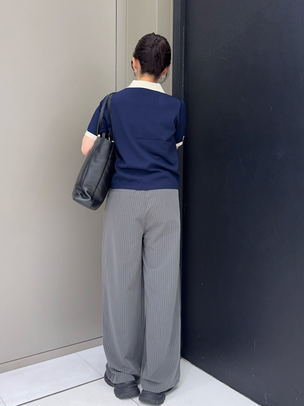 ブルー系のニット/セーター、グレー系のその他パンツ、ブラック系のスニーカーを着用したレディースの春コーディネートの2枚目の写真