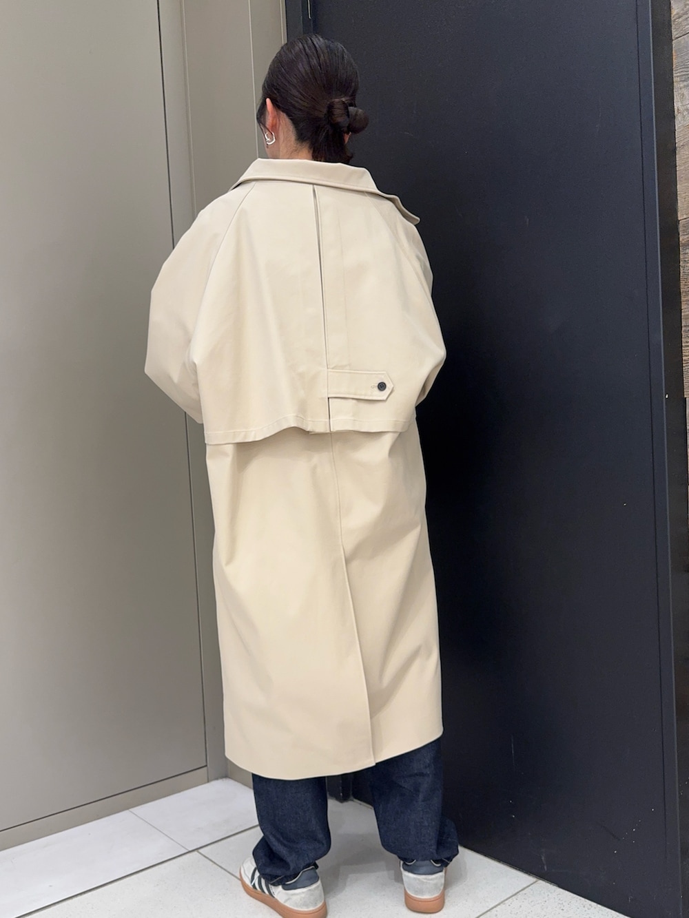 ブラウン系のハンドバッグ、ベージュ系のその他アウター、ブルー系のデニムパンツを着用したレディースの春コーディネートの3枚目の写真