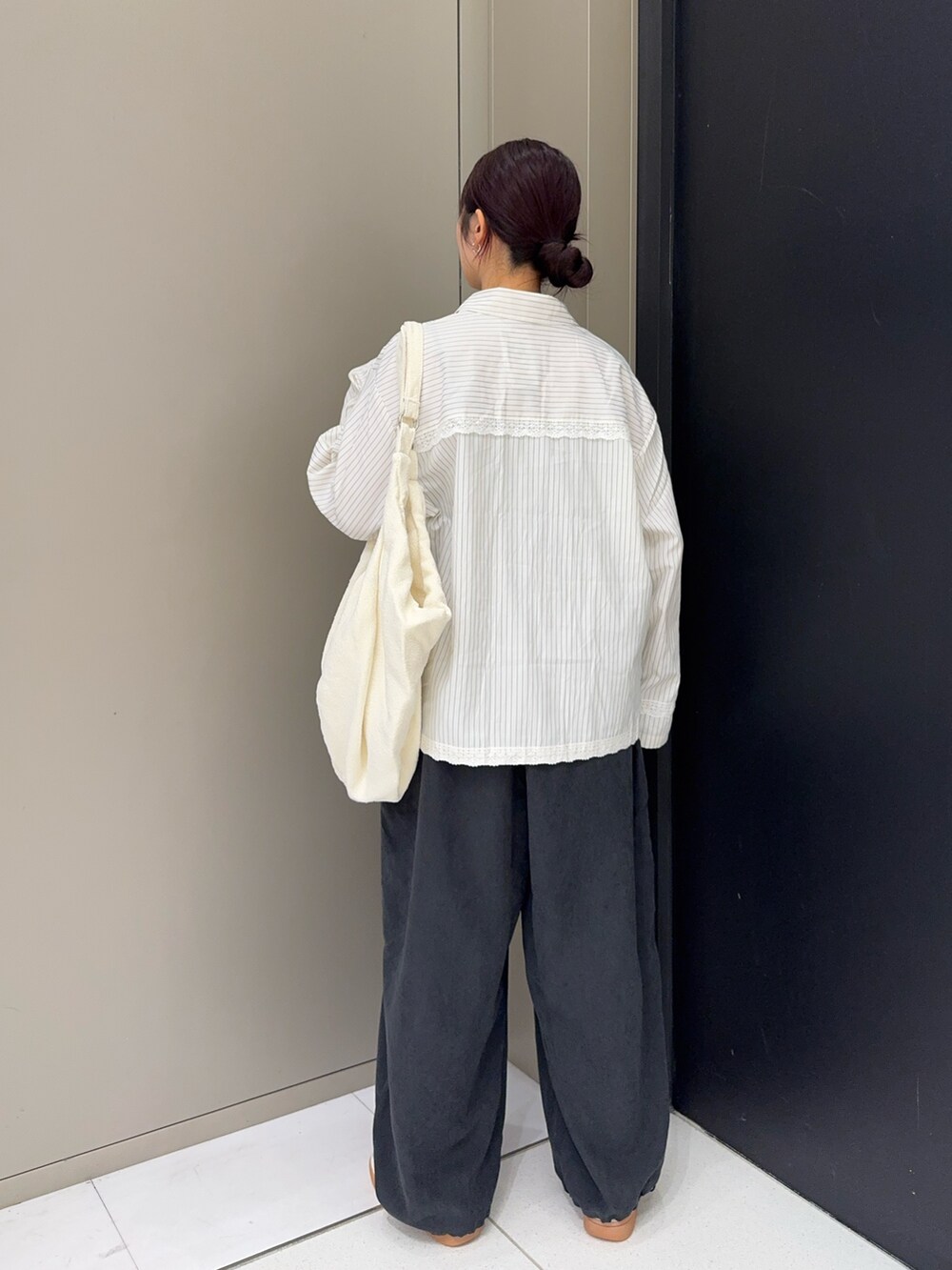 グレー系のその他パンツ、ホワイト系のトートバッグ、ホワイト系のシャツ/ブラウスを着用したレディースの秋コーディネートの2枚目の写真