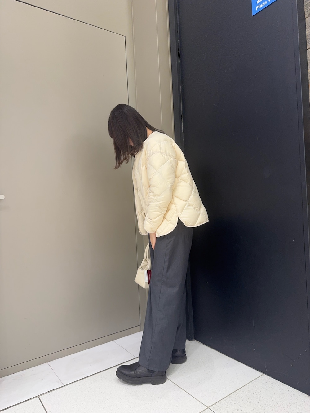 ホワイト系のダウンジャケット/コート、ホワイト系のハンドバッグを着用したレディースの冬コーディネートの2枚目の写真