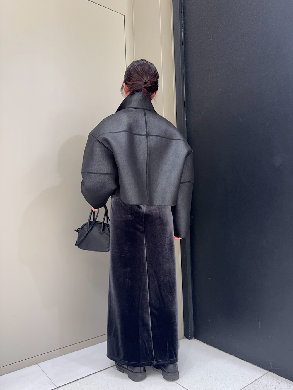 ブラック系のその他アウター、ブラック系のハンドバッグ、グレー系のスカートを着用したレディースの冬コーディネートの4枚目の写真