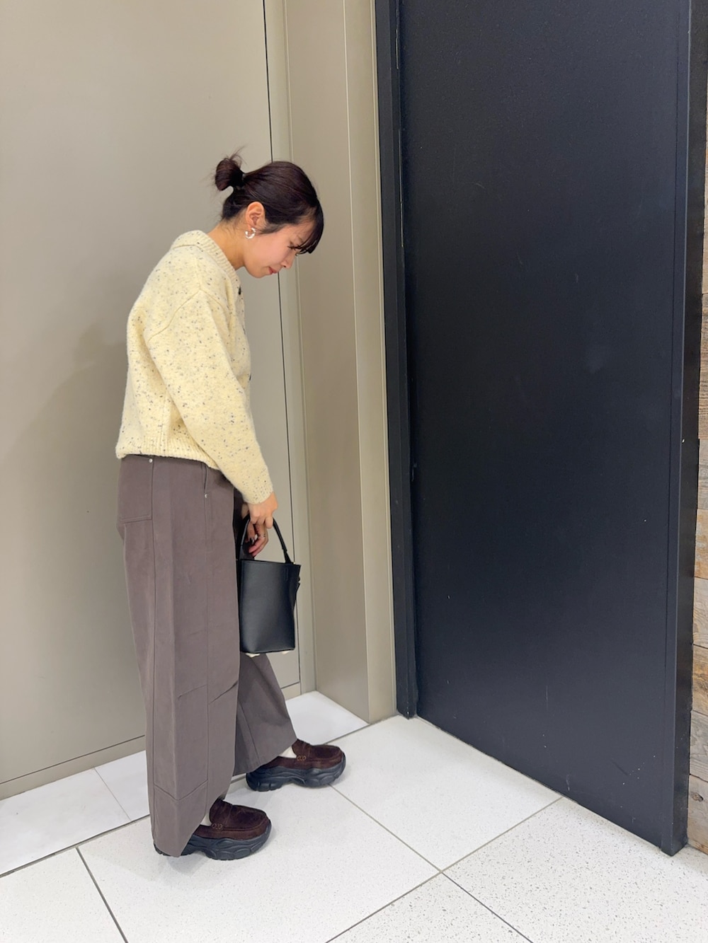 ベージュ系のカーディガン/ボレロ、グレー系のその他パンツ、ブラウン系のローファーを着用したレディースの冬コーディネートの2枚目の写真