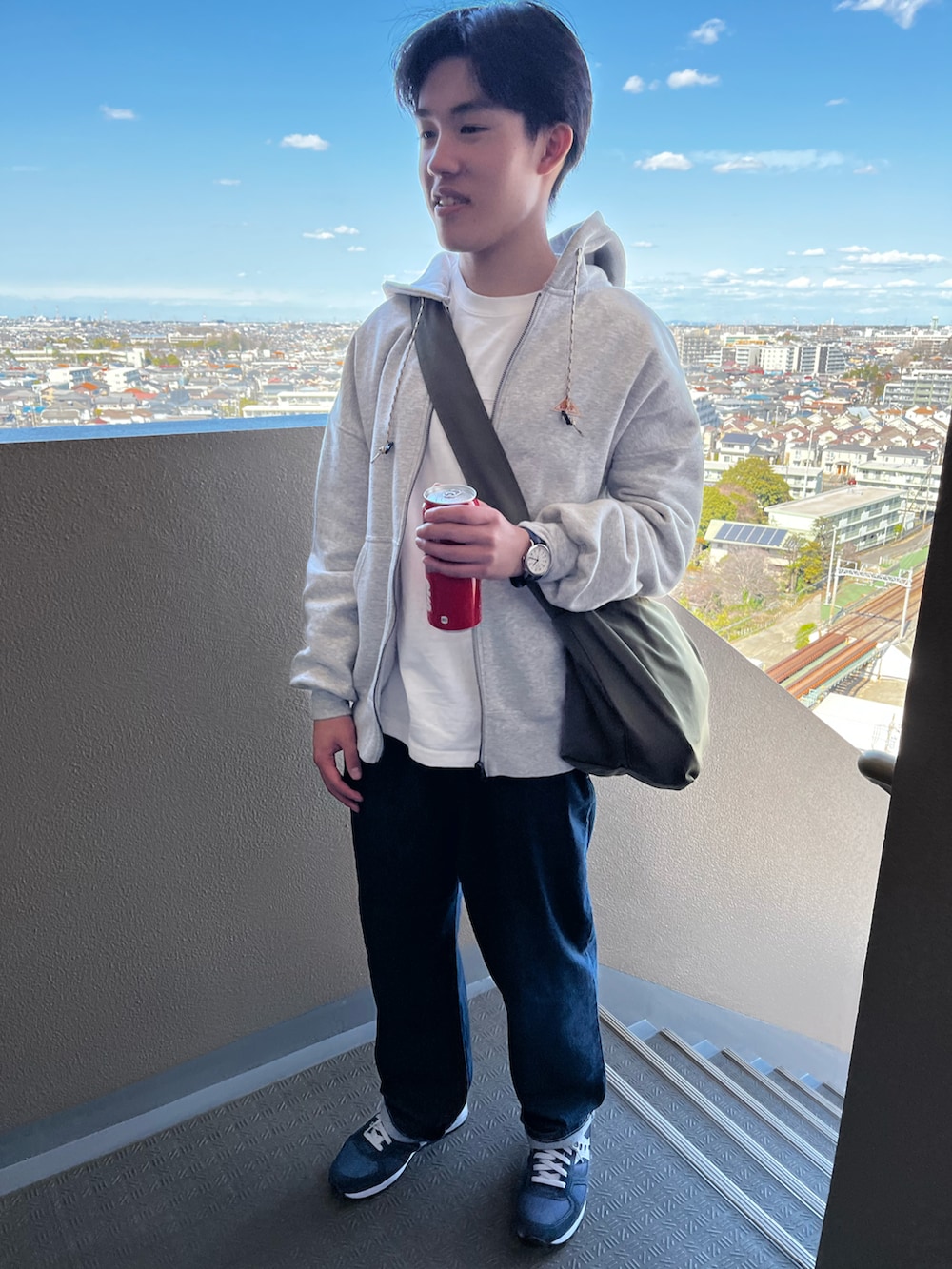 グレー系のパーカー、ブルー系のデニムパンツ、ブルー系のスニーカーを着用したキッズの春コーディネートの2枚目の写真