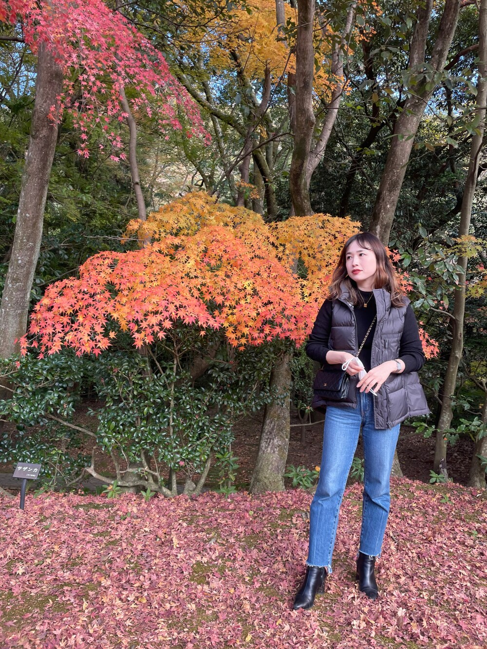 グレー系のダウンベスト、ブルー系のデニムパンツを着用したレディースの秋コーディネートの2枚目の写真