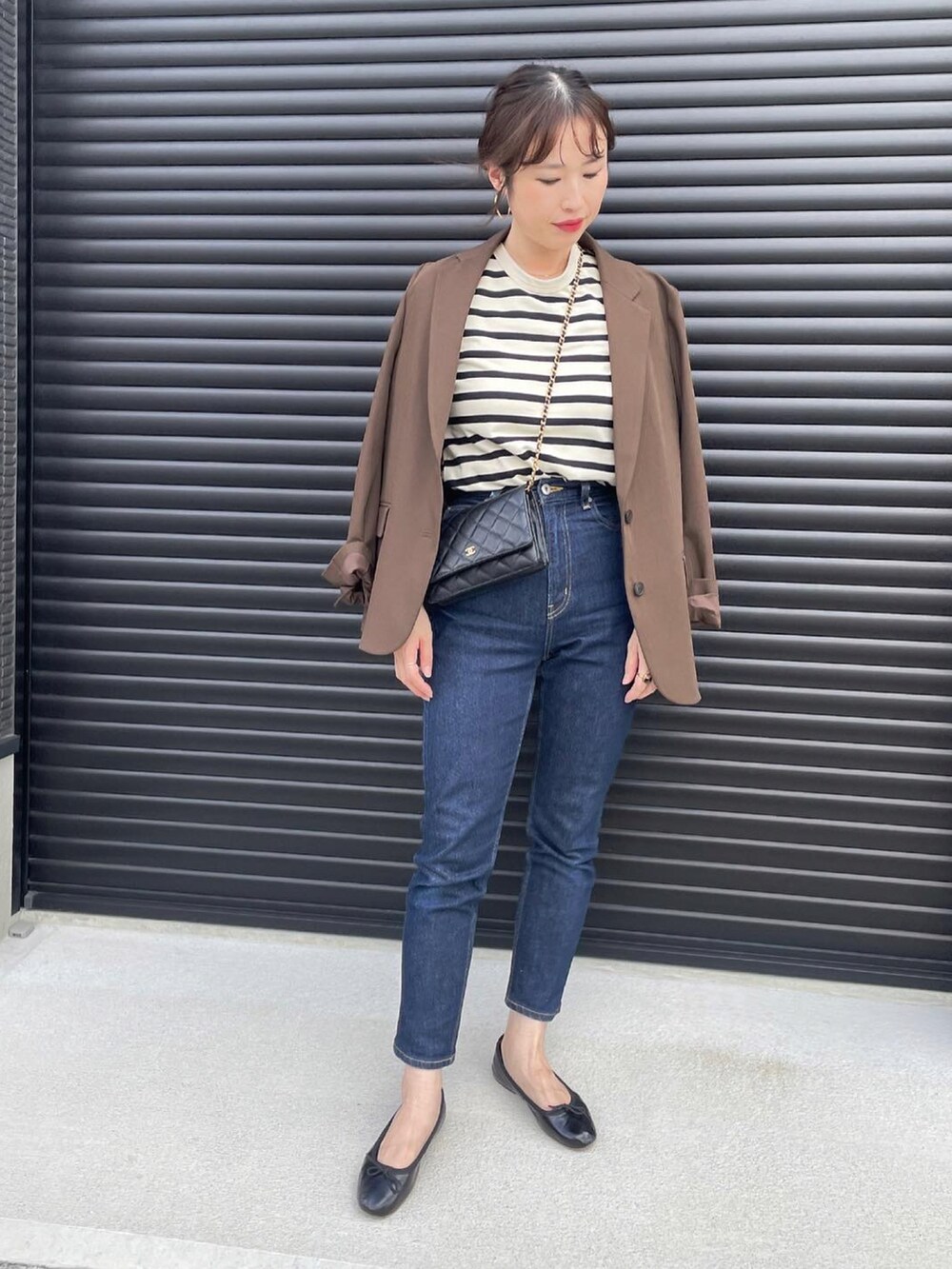 ホワイト系のトップス、ブルー系のデニムパンツ、ブラウン系のテーラードジャケットを着用したレディースの秋コーディネートの2枚目の写真