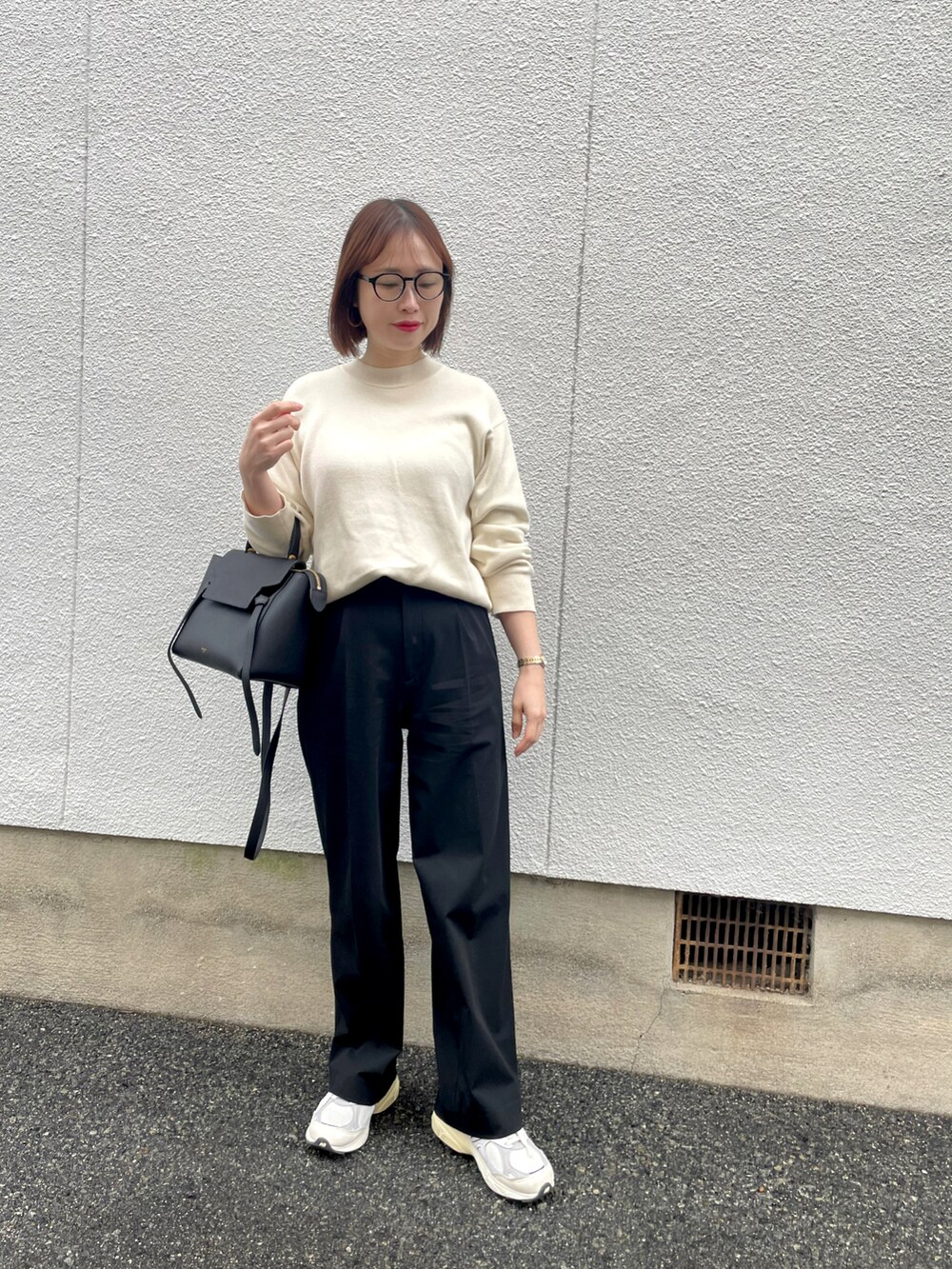 ホワイト系のスニーカー、ホワイト系のニット/セーター、ブラック系のパンツを着用したレディースの冬コーディネートの2枚目の写真